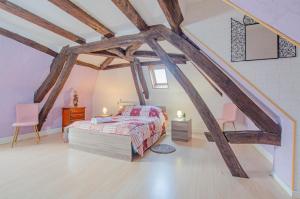 1 dormitorio con 1 cama y 2 sillas en el ático en Gite de la bouvotte, en Neuville-sur-Vanne