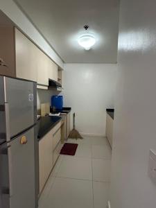 eine Küche mit weißen Schränken und einem Kühlschrank in der Unterkunft Abl@home in Angeles