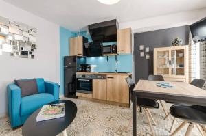 a living room with a table and a blue couch at Gite de la barse in Vendeuvre-sur-Barse