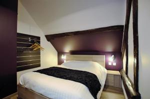 una camera da letto con un grande letto bianco e pareti viola di Le saint vincent ii a Villenauxe-la-Grande