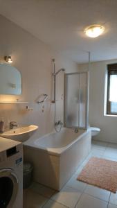 a large white bathroom with a tub and a sink at Ferienwohnungen Bauer in Kurort Oberwiesenthal