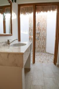 a bathroom with a sink and a shower at Zanzibar Bahari Villas in Matemwe