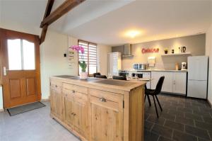 una cocina con una gran isla de madera en una habitación en Au vieux chene, en Ormes