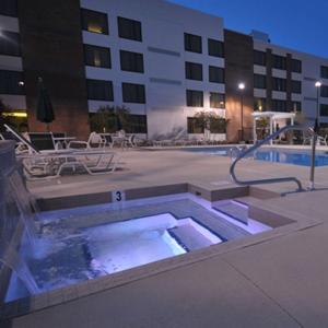 une piscine avec un bain à remous en face d'un bâtiment dans l'établissement DoubleTree by Hilton Rocky Mount, à Rocky Mount