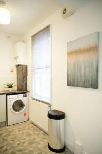 a kitchen with a washing machine and a window at Aqua Springs, luxury 2 bed, 2 bath apartment, near Didsbury in Manchester