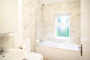 ein Badezimmer mit einer Badewanne, einem WC und einem Waschbecken in der Unterkunft Aqua Springs, luxury 2 bed, 2 bath apartment, near Didsbury in Manchester