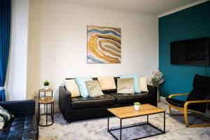 ein Wohnzimmer mit einem Sofa und einem Tisch in der Unterkunft Aqua Springs, luxury 2 bed, 2 bath apartment, near Didsbury in Manchester