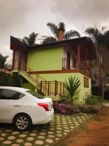 a white car parked in front of a house at Chalés Vani in Resende