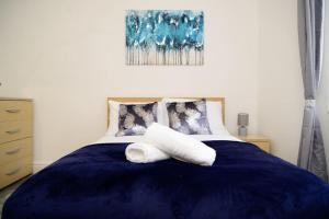 a bedroom with a blue bed with two pillows at Aqua Springs, luxury 2 bed, 2 bath apartment, near Didsbury in Manchester