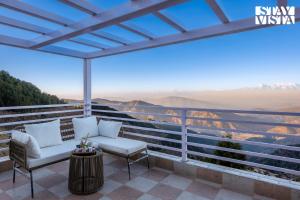 a balcony with chairs and a view of the mountains at StayVista at Alpine Haven - Mukteshwar in Rāmgarh