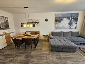ein Wohnzimmer mit einem Sofa und einem Tisch in der Unterkunft FEWO FAUBEL Mülheim Forum City 60 m2 in Mülheim an der Ruhr