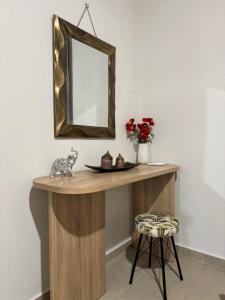 a dressing table with a mirror and a stool at Alleyhouse 83 in Kremasti