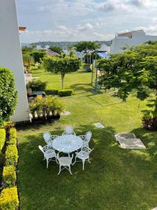 a table and chairs sitting in a yard with a grassy field at Casa vacacional Tequesquitengo in Tequesquitengo