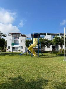 un parque infantil con tobogán amarillo en Casa vacacional Tequesquitengo, en Tequesquitengo