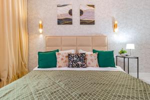 een slaapkamer met een groot bed met kleurrijke kussens bij Комфортабельная квартира в ЖК Apple City in Astana