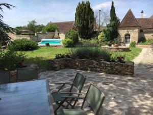 un patio con sillas, una mesa y una piscina en Le saint vincent i en Villenauxe