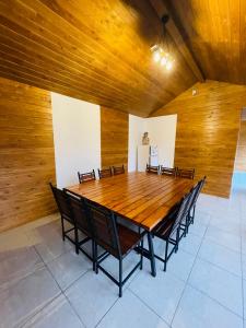een houten tafel in een kamer met stoelen eromheen bij Hidden Cabin in Brezoi