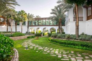 einen Innenhof mit Palmen und ein Gebäude in der Unterkunft Park Hyatt Dubai in Dubai