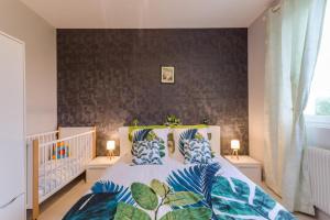a bedroom with a large bed with blue pillows at La rose d'henri in Landreville