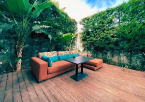 un divano e un tavolo su una terrazza in legno di Cozy Villa With Pool and Indoor Fireplace a Casablanca