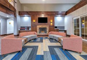 a lobby with chairs and a fireplace and a tv at La Quinta by Wyndham Fort Worth NE Mall in Hurst