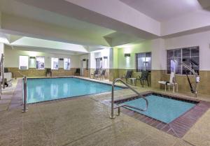 a pool at a hotel with tables and chairs at La Quinta by Wyndham Fort Worth NE Mall in Hurst