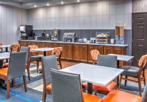 a restaurant with tables and chairs and a kitchen at La Quinta by Wyndham Fort Worth NE Mall in Hurst