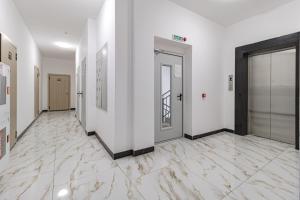 een hal met witte muren en marmeren vloeren bij Комфортабельная квартира в ЖК Apple City in Astana