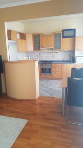 eine große Küche mit Holzschränken und einem Tisch in der Unterkunft Apartment 345 in Kutná Hora