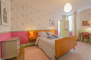 a bedroom with a bed in a room with pink walls at Parenthese in Villenauxe