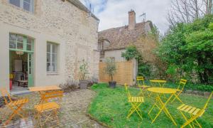 a patio with yellow tables and chairs and a table at Parenthese in Villenauxe-la-Grande