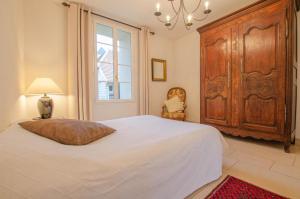 a bedroom with a large bed and a large wooden cabinet at Le cottage in Payns