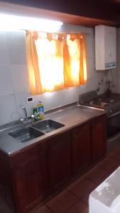 Una cocina con fregadero, estufa y ventana. en Descanso Punta Mogotes, en Mar del Plata 18 fotos más