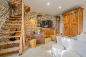 ein Wohnzimmer mit einer Steinmauer und einer Treppe in der Unterkunft Gite de l'entente in Macey