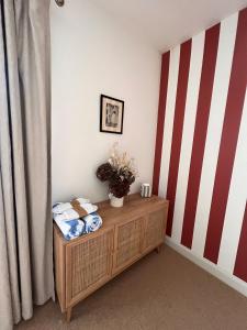 a room with a wooden cabinet and a striped wall at Lido Townhouse in Bristol