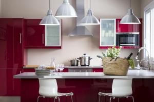 una cocina con armarios rojos y sillas blancas en La goutte d'or en Baroville