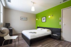 1 dormitorio verde con 1 cama y 1 silla en La goutte d'or en Baroville