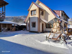 a house being constructed in the snow at Нота Карпат in Skole