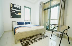 迪拜Citi home Business bay的一间卧室，里面有一张床、一把椅子和一扇窗户