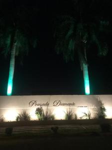 a building with two palm trees in the background at Pousada Diamante in Bonito