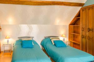 2 Betten in einem Zimmer mit blauen Kissen in der Unterkunft Le beau lieu in Maizières-la-Grande-Paroisse