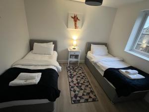 two twin beds in a room with a cross on the wall at Mayland Motel 