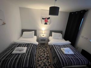 2 camas individuales en una habitación con lámpara en Mayland Motel 