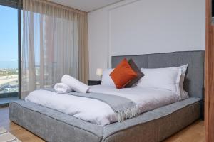 una camera da letto con un grande letto con cuscini arancioni e bianchi di Apartment Sea View B2 - Mosquée Hassan II - By TheCasaEdition a Casablanca