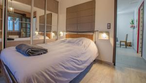 ein großes Bett in einem Schlafzimmer mit einem Spiegel in der Unterkunft La met au loup in Charmont-sous-Barbuise
