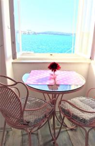 een tafel met een bloem erop voor een raam bij Main Square Apartments with sea view in Pula