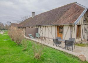 JeugnyにあるLa louviereの庭にテーブルと椅子が備わるコテージです。