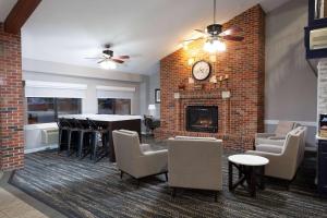 a living room with a brick wall and a fireplace at AmericInn by Wyndham Peoria in Peoria