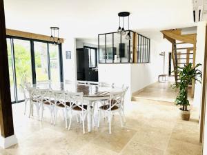 a dining room with a white table and chairs at Au naturel in Montreuil-sur-Barse