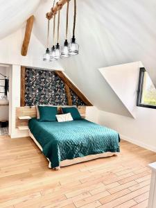 a bedroom with a green bed in a attic at Au naturel in Montreuil-sur-Barse